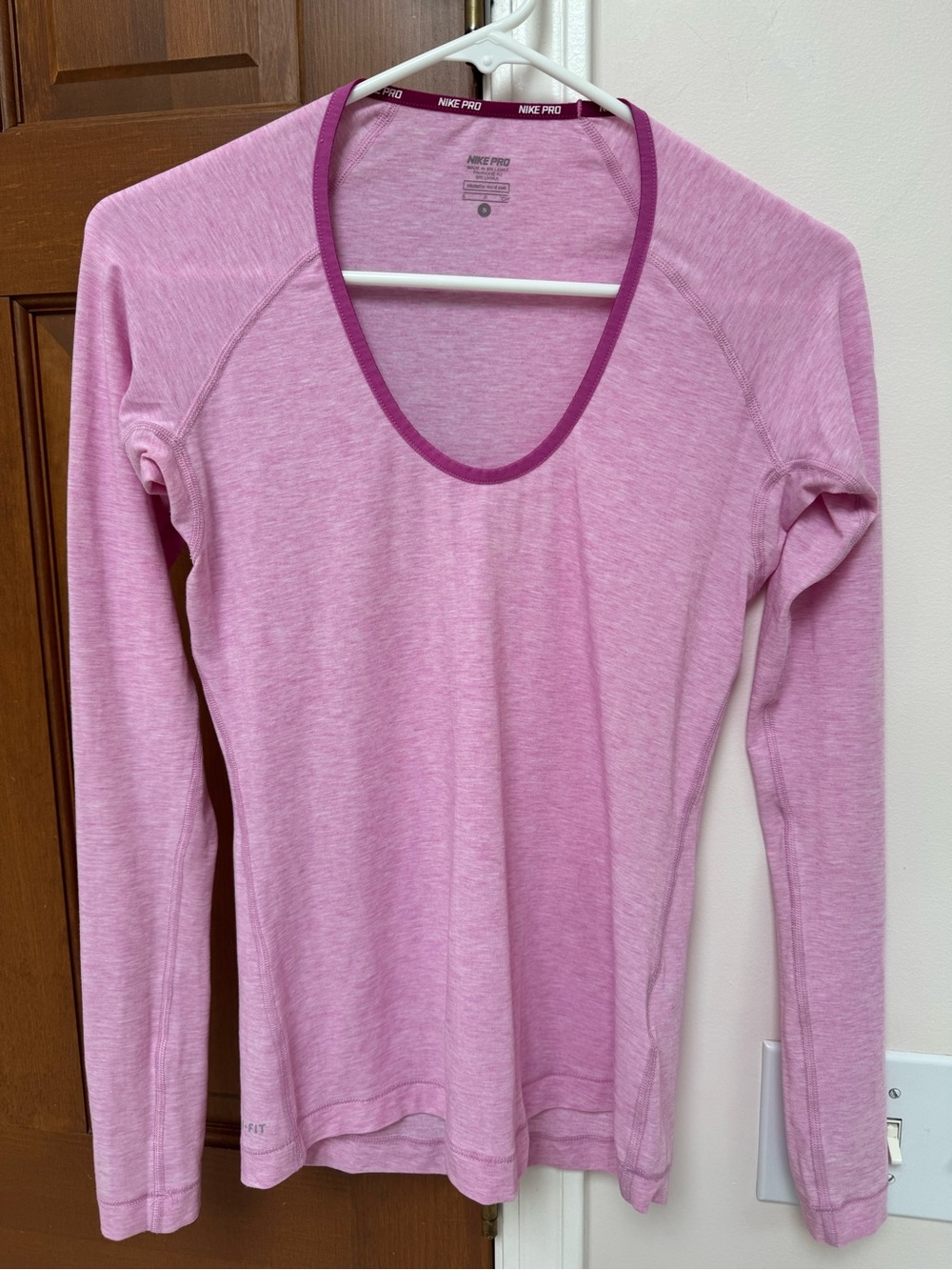 Nike Pro pink long-sleeve activewear shirt featuring a deep scoop neckline